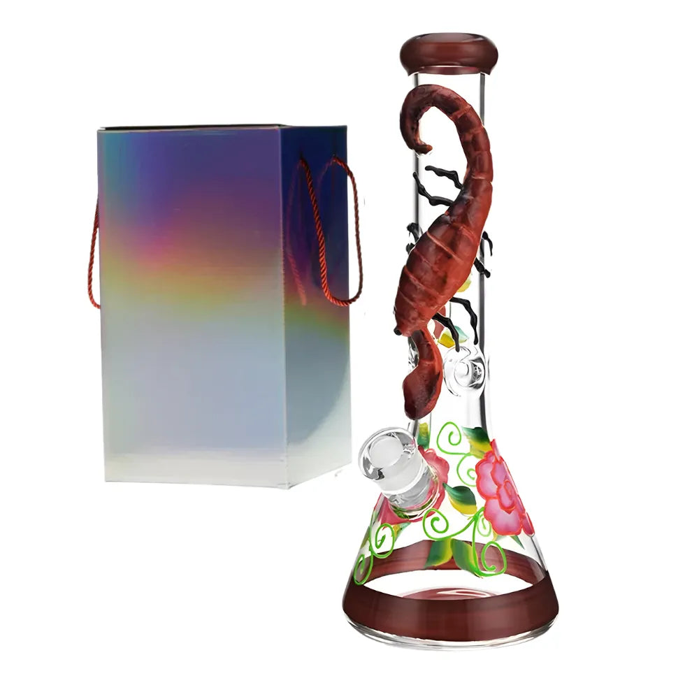 Glass smoking bong with a 3d scorpion and colourful base and floral accents, next to a rainbow-coloured box.