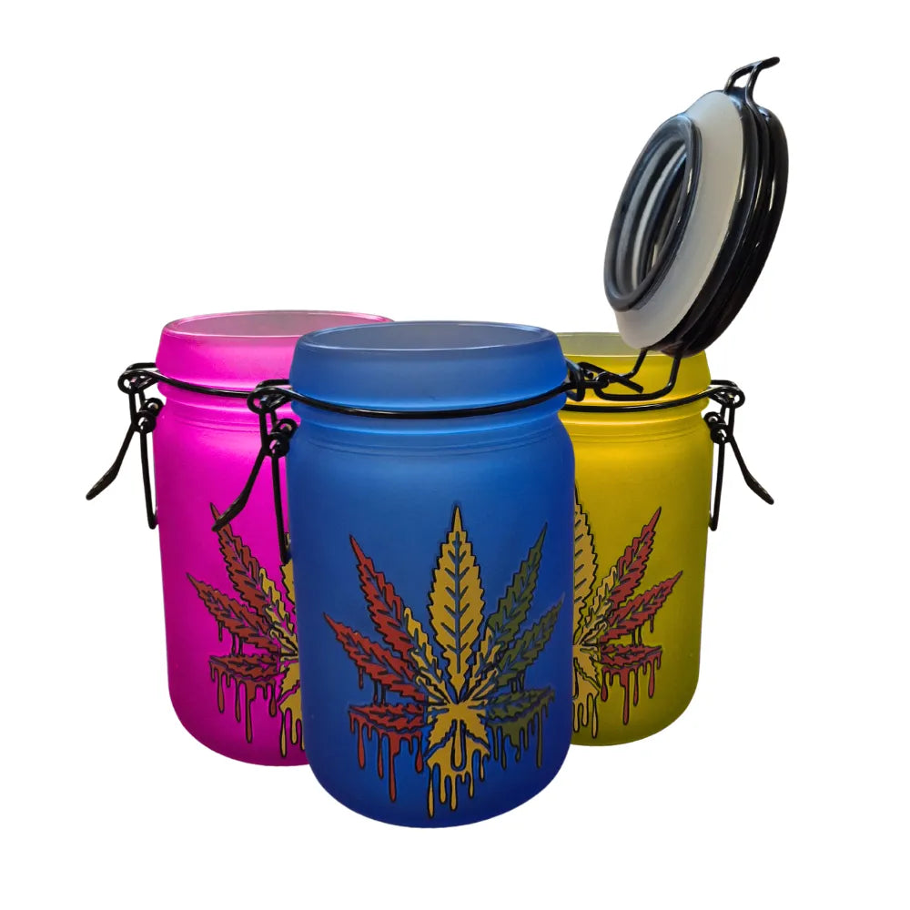 Three colourful glass jars with cannabis leaf designs on a white background
